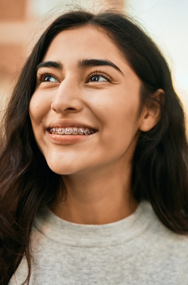 Need Emergency Care? Quick Solutions for Orthodontic Issues. A girl is playfully smiling with her braces