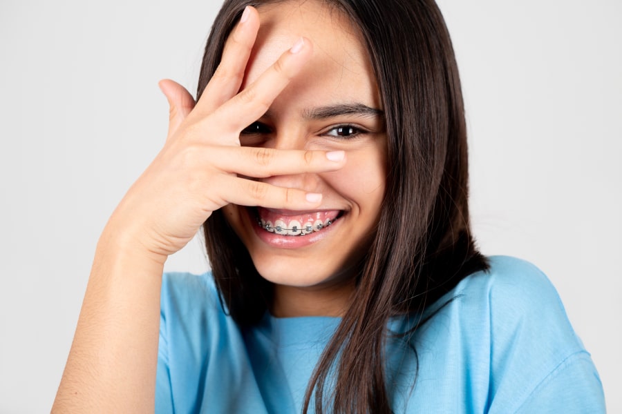 Discover the Benefits of Damon™ Smile – Efficient, Discreet, and Effective Orthodontic Treatment. A girl with braces is smiling